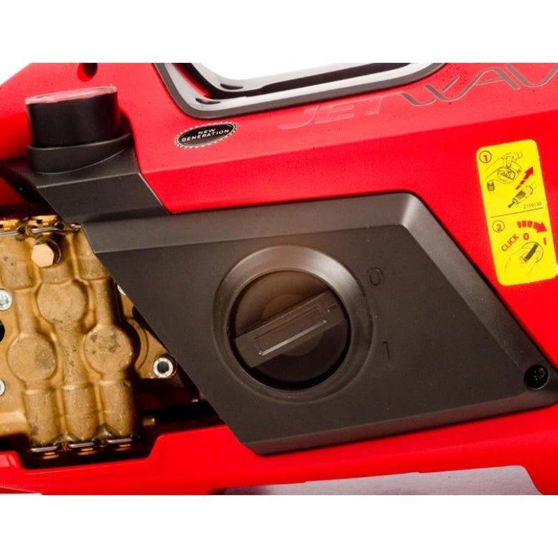 Close-up of a red pressure washer with visible branding and warning label.